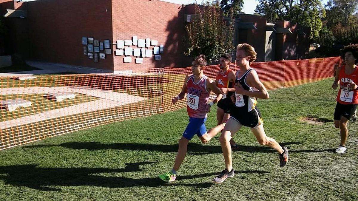 Kamiakin’s Jonah Franco (center, background) gets ready to make his move on Eisenhower’s Jonas Price (left) and Bishop Kelly’s Nicholas Russell in the 3-mile Boys Elite race Saturday at Franklin Park in Yakima. Franco won the race in 15:33.61, and was one of six Braves to win their respective varsity heats to easily run away with the team title.