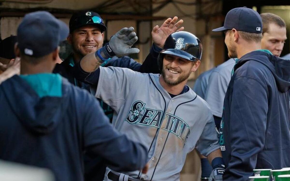 Seattle Mariners' Shawn O'Malley is greeted in the dugout by his teammates after hitting a home run off Oakland Athletics relief pitcher Arnold Leon during the 2015 season.