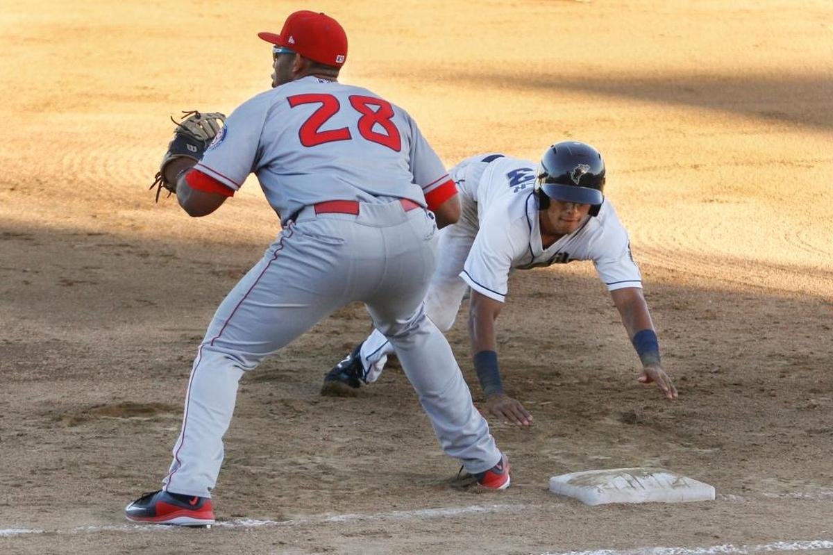 Spokane Indians first baseman Curtis Terry (28) attempts to tag out Tri-City Dust Devils Tre Carter (33) as he slides back into first base during a home game on Tuesday at Gesa Stadium in Pasco.