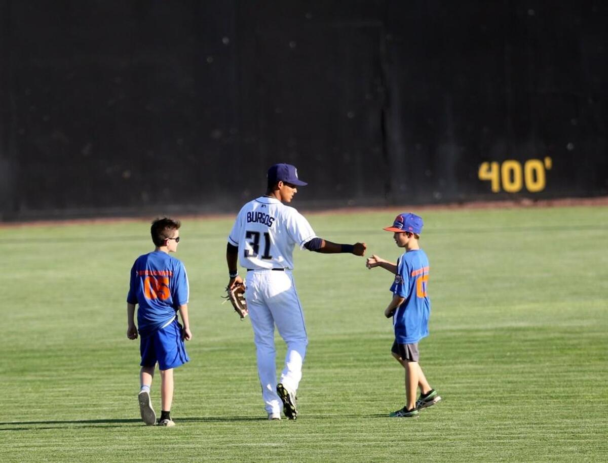 Dust Devils outfielder Aldemar Burgos gives a fan a fist bump before a game at Gesa Stadium during the 2016 season.