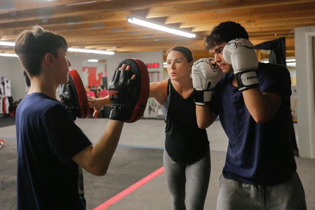 Sarah Howell works with a pair of students inside of her Pasco gym, Wolfpack MMA & Fitness.