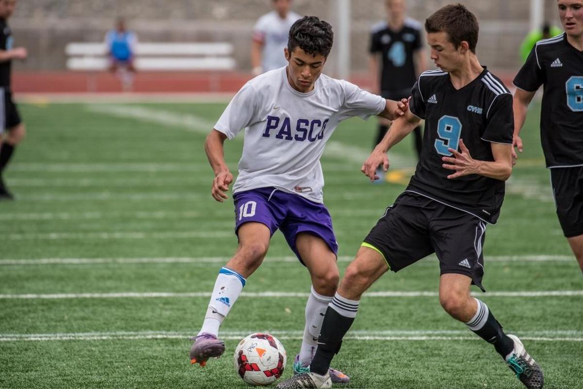 Pasco sophomore Edwin Aquino battles Reece Bumgarner of Central Valley in the first half of a regional playoff game at Edgar Brown Stadium in Pasco.