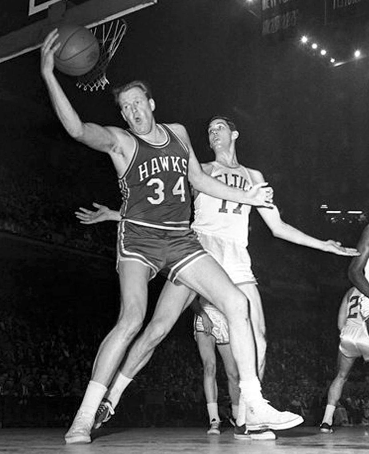 This Jan. 13, 1960, file photograph shows Boston Celtics forward Gene Conley, right, defending against St. Louis Hawks Clyde Lovellette (34) during a basketball game in Boston. Conley, who died July 4, played for both the Celtics and as a pitcher for the Boston Red Sox.