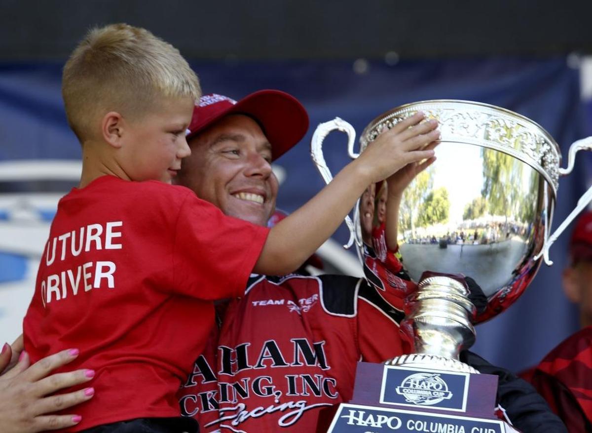 J. Michael Kelly, driver of the U-5 Graham Trucking boat, holds the 2016 HAPO Columbia Cup and his son Carson, 7, after being named the winner of the race. However, an appeal by the U-1 team to the APBA resulted in an overruling of the decision and gave Jimmy Shane the title in December.