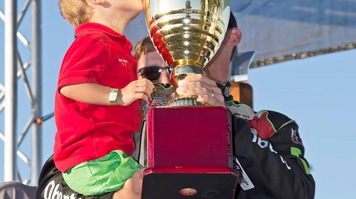 
Colton Shane, son of U-1 Oberto driver Jimmy Shane, kisses the victory trophy Sunday after his dad (behind trophy), won the Bayfair Regatta championship final in San Diego.
