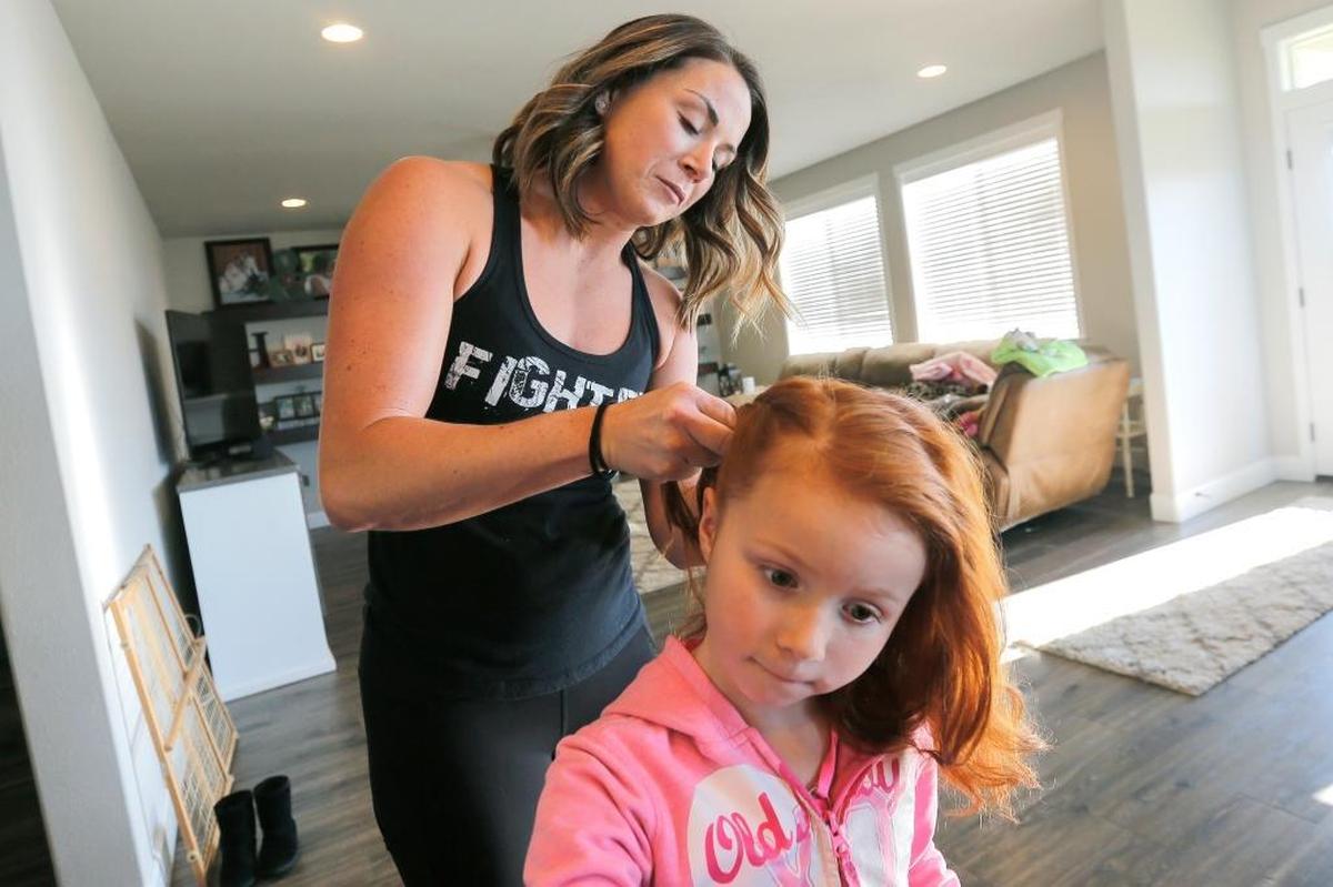 Sarah Howell braids her daughter Paisley’s hair at their home in Pasco.