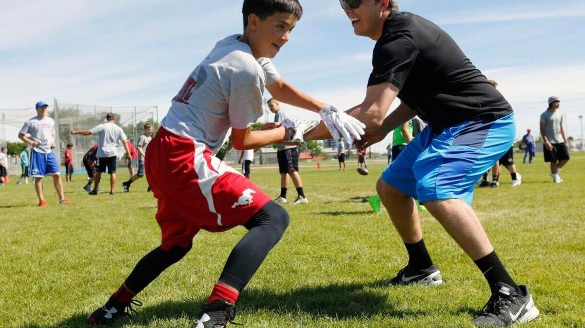 Dallas Cowboys quarterback Kellen Moore, right, originally of Prosser, squares off against Brock Weimann, 13 of Prosser on Saturday during the Kellen Moore Passing Academy in Richland. Kellen and his father Tom Moore hosted the annual camp to work with area kids on football technique.