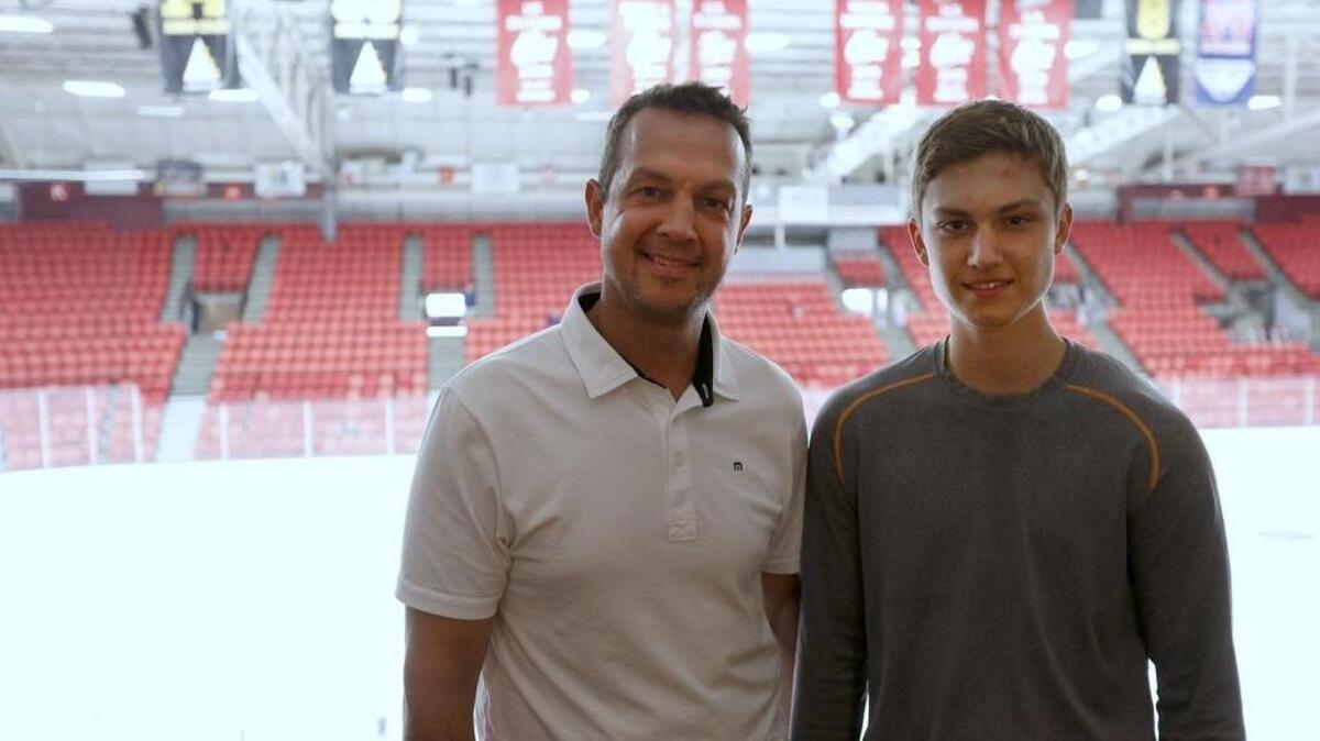 
Stu Barnes poses with his son Jack at Toyota Center in Kennewick with his retired number banner hanging behind them. Stu played two seasons with the Tri-City Americans and is a part owner of the team that drafted Jack in May.
