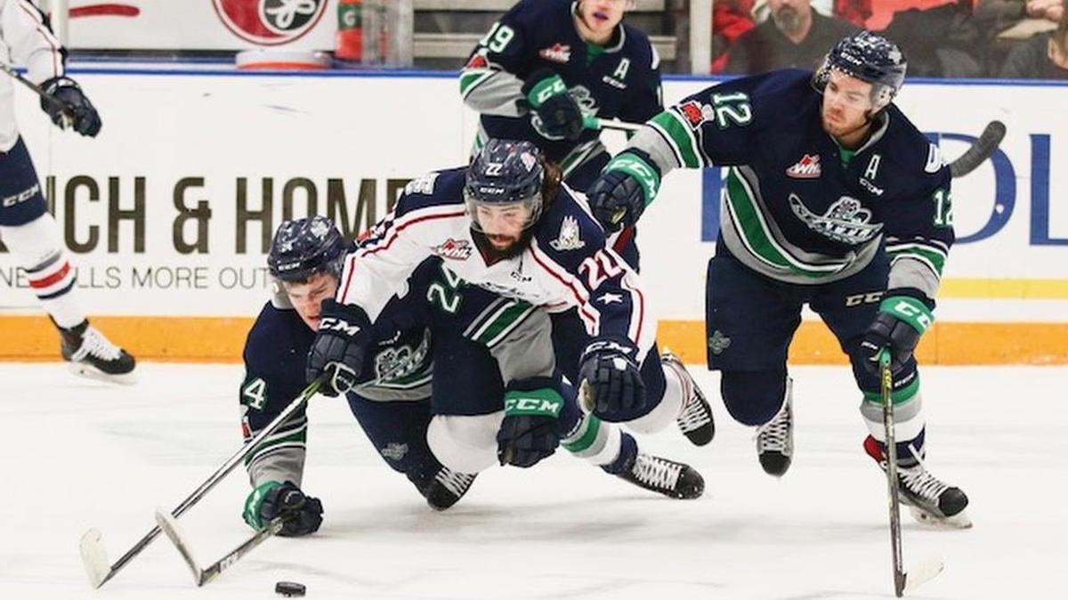 Tri-City's Nolan Yaremko (center) dives after a puck with Seattle's Jake Lee (24) and Blake Bargar (12) during Sunday's game at Toyota Center.