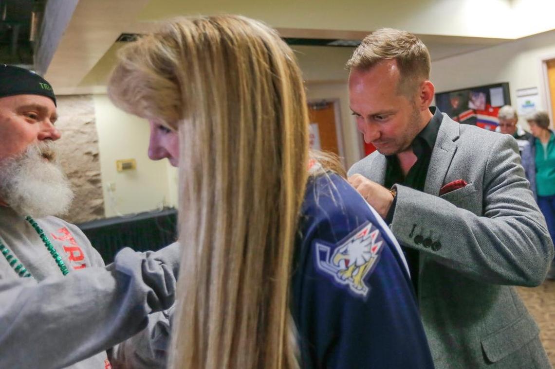Former Tri-City Americans captain Ben Kilgour signs Kathy Holloway’s jersey Saturday at Toyota Center in Kennewick during a meet and greet before the Americans played Spokane.