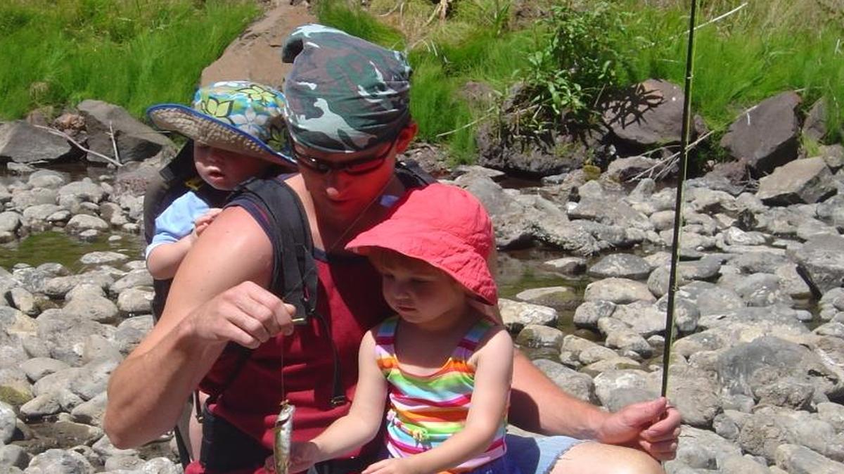 Dennis Dauble’s son, Matthew, carried on his father’s fishing tradition with his two children, Adam (backpack) and Annalise, shown here with her first trout on a fly rod.